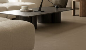 Detaljbilde av stue med flislagt gulv i jordfarge