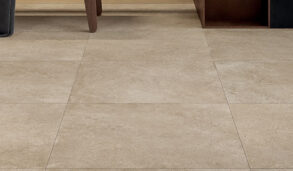 Detaljbilde av gulv flislagt med storformat flis i en varm, beige farge