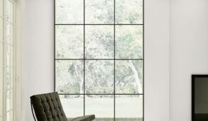 Stue i hvite nyanser med sorte kontraster. Gulv flislagt med hvit, keramisk marmorflis